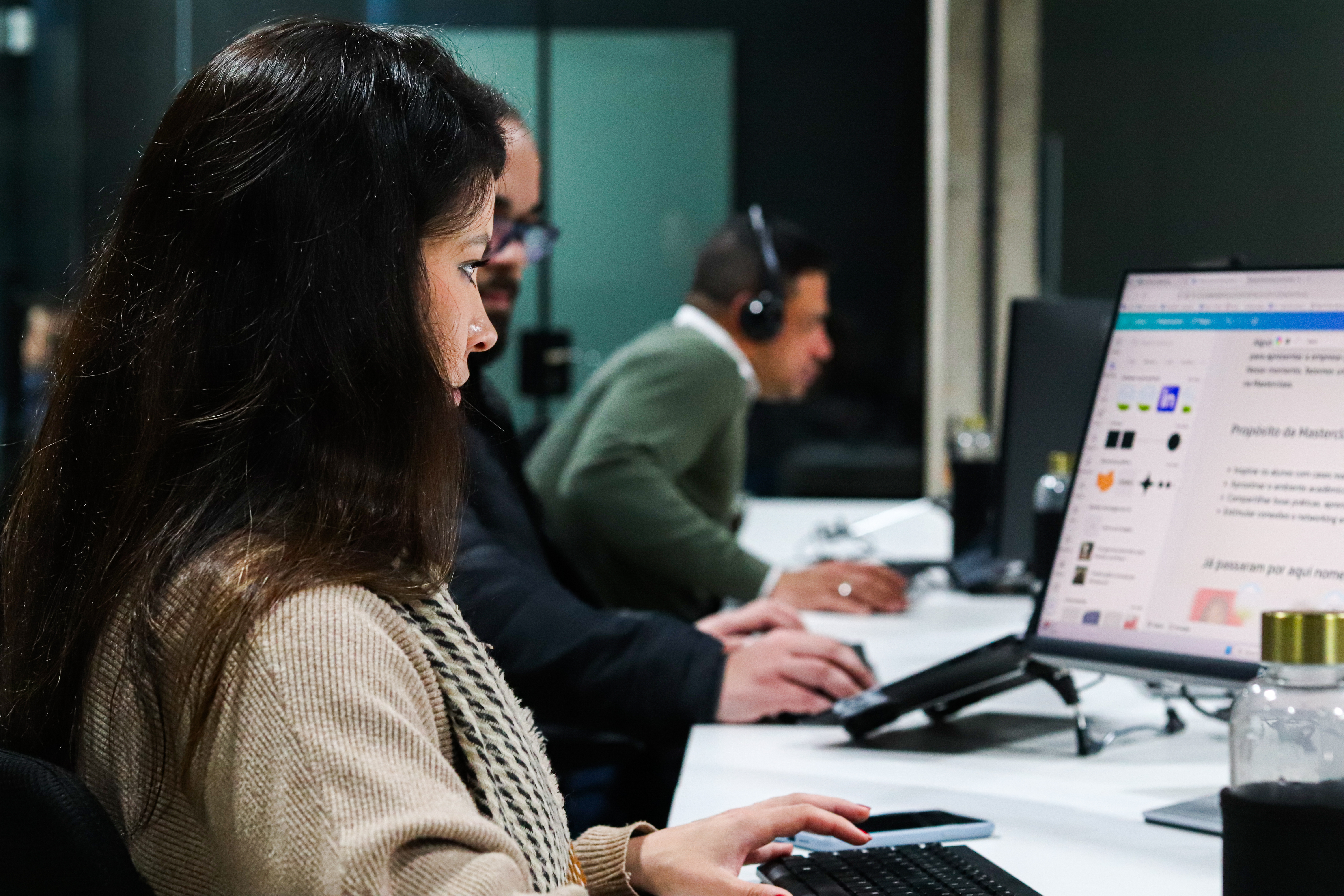 Equipe trabalhando lado a lado em computadores no escritório da Inbix