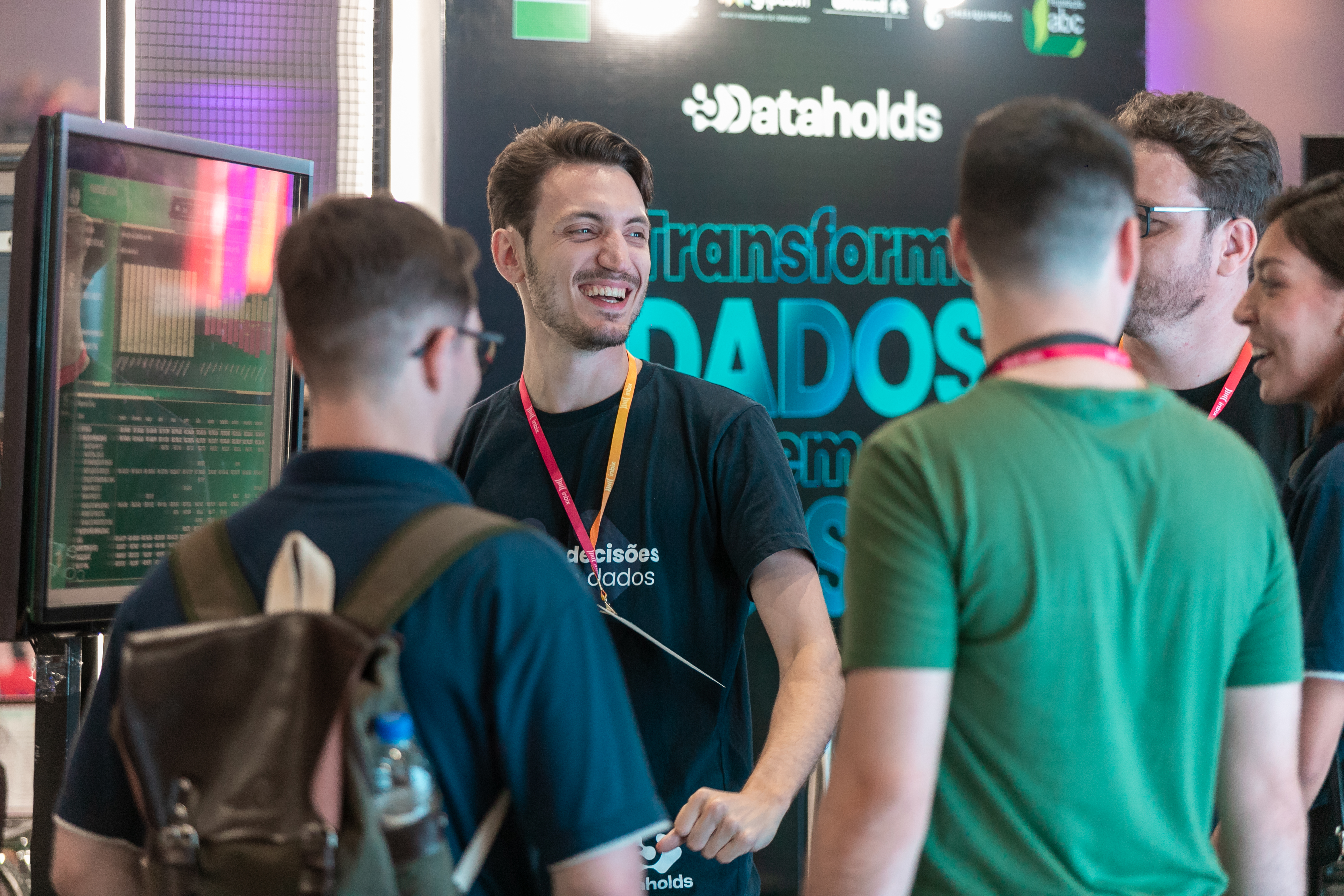 Profissionais conversando no estande de uma empresa de dados durante evento
