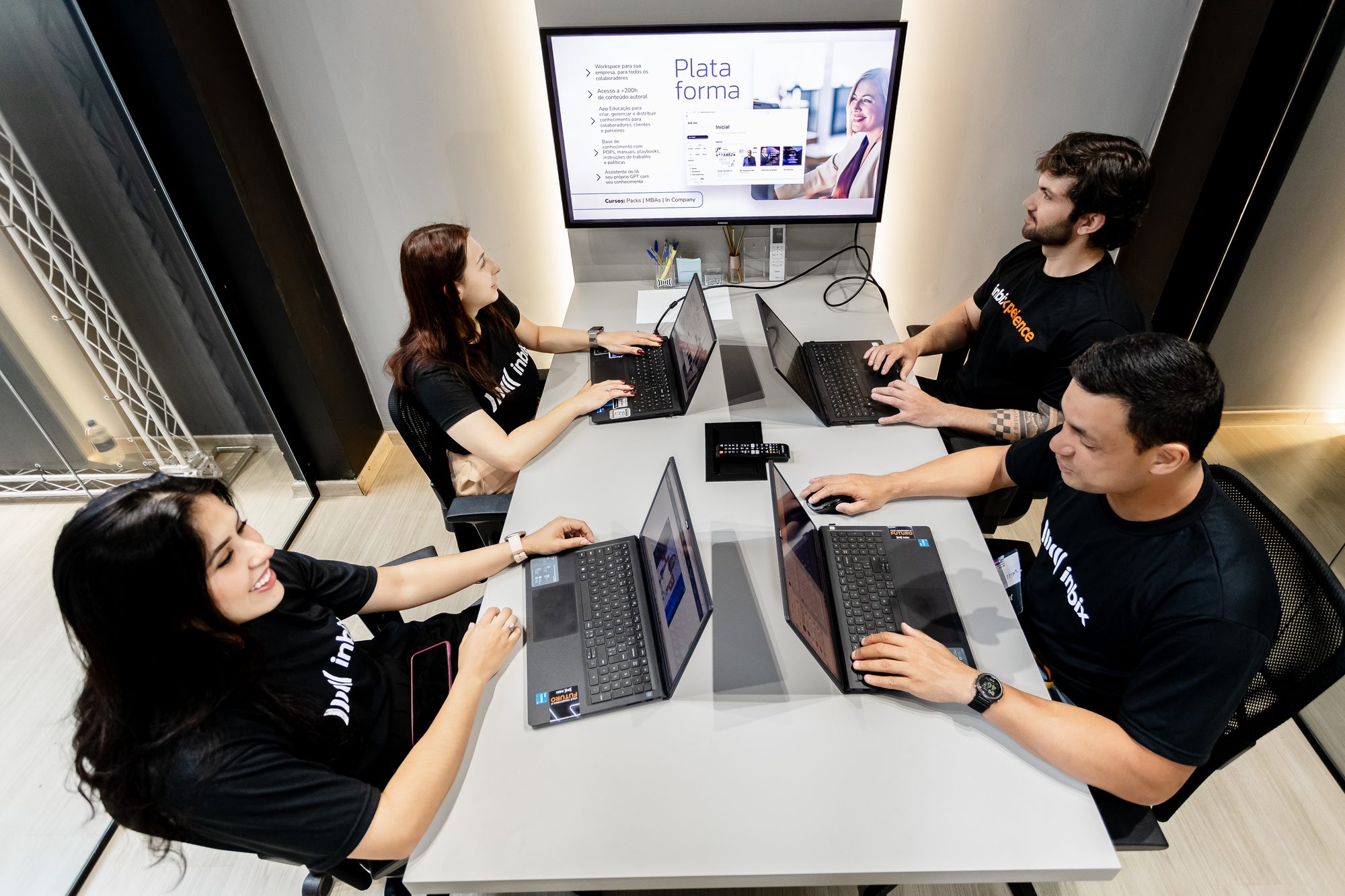 Equipe da Inbix em reunião diante do telão com a plataforma aberta