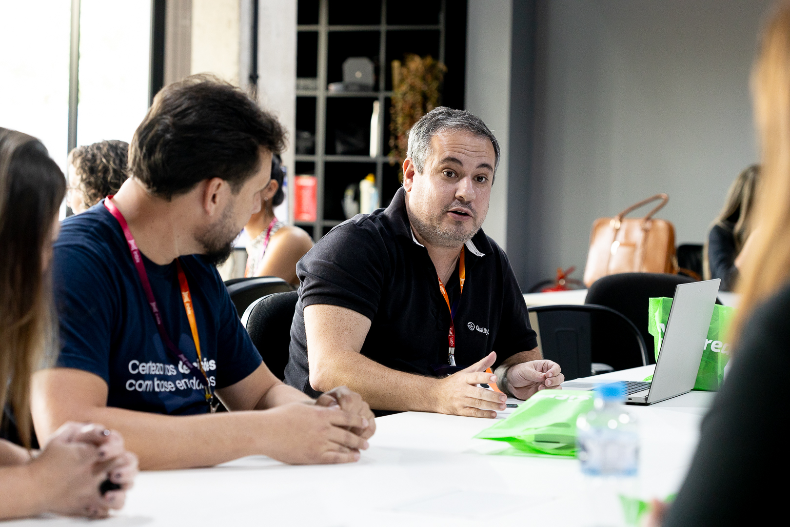 Participante expondo uma ideia em dinâmica de grupo ao redor da mesa