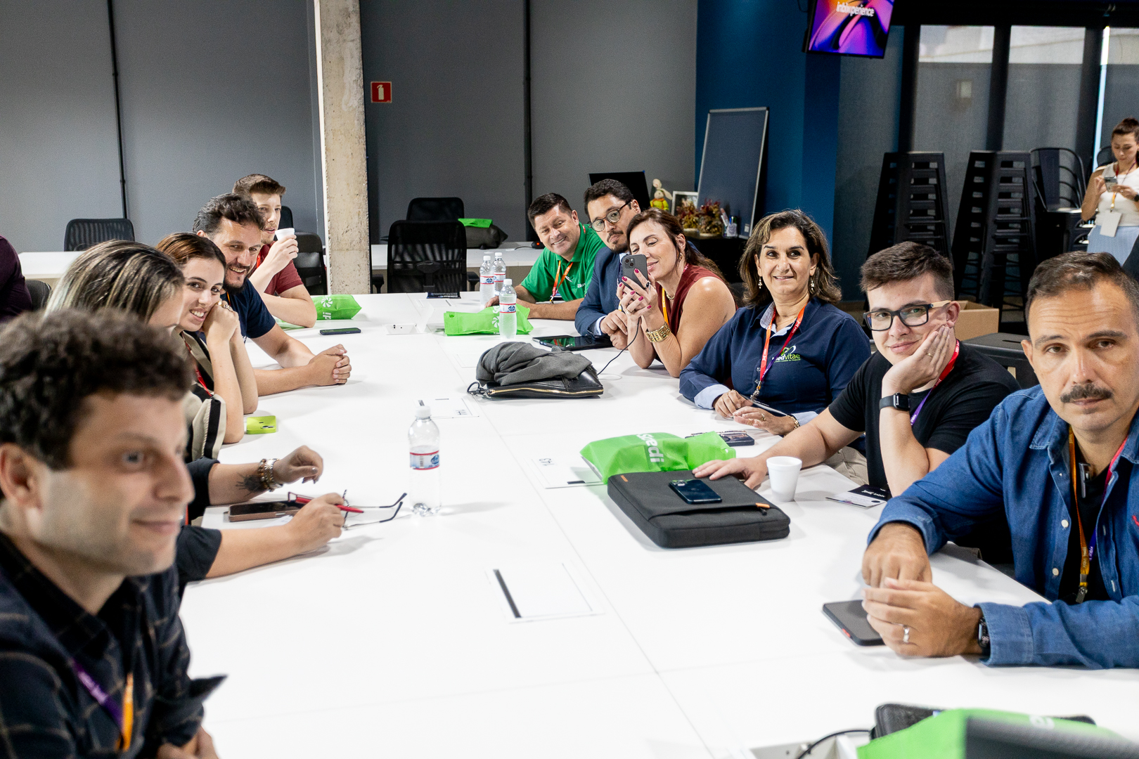 Participantes reunidos em mesa longa durante uma dinâmica de grupo